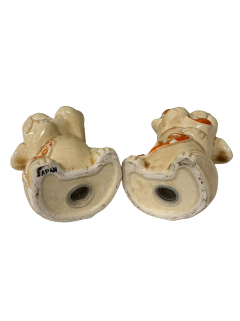 Dog holding a telephone salt and pepper shakers